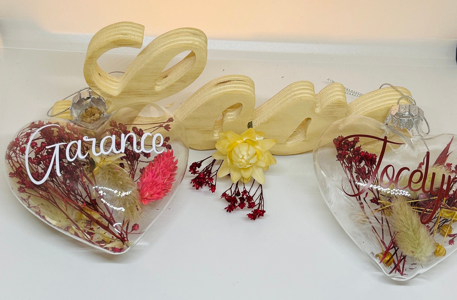 Boule de Noël en verre personnalisée en forme de coeur avec fleurs séchées pour décorer son sapin